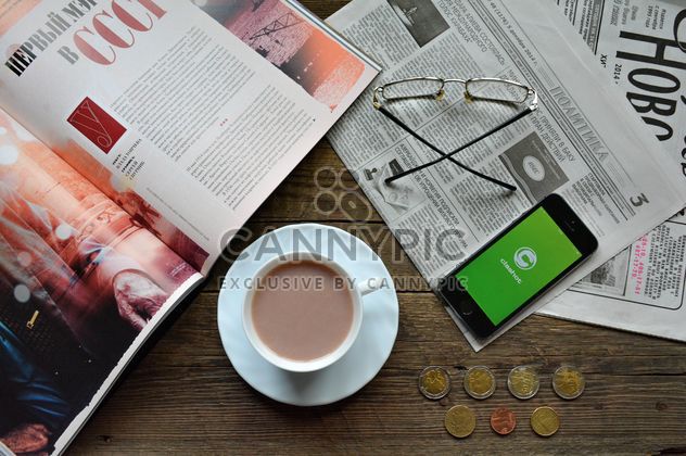 Cup of coffee, daily press and smartphone with Clashot logo on the table - image #182811 gratis