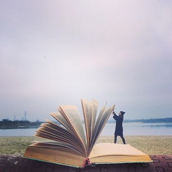 Small girl leafing through a big book - бесплатный image #183701