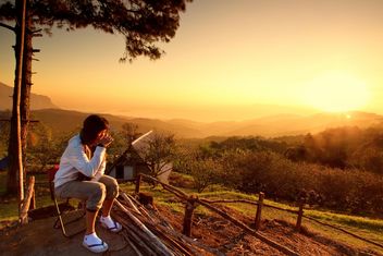 Woman watching sunset with a cup of warn drink - image gratuit #184271 