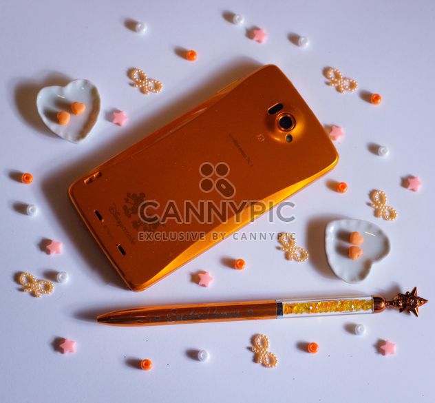 orange smartphone with little hearts and and bows - image #187231 gratis