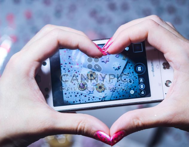 Smartphone decorated with tinsel in woman hands - image gratuit #342171 