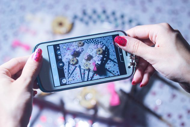 Smartphone decorated with tinsel in woman hands - image #342181 gratis