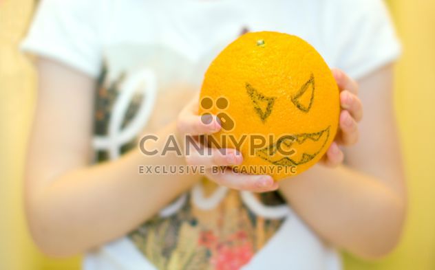Angry orange for Halloween in child's hands - image #348011 gratis