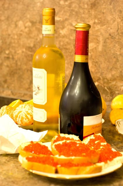 Sandwiches with red caviar and bottles of wine - бесплатный image #348031
