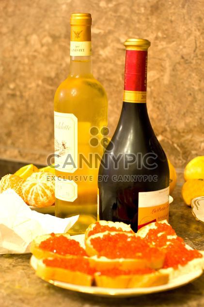 Sandwiches with red caviar and bottles of wine - Free image #348031