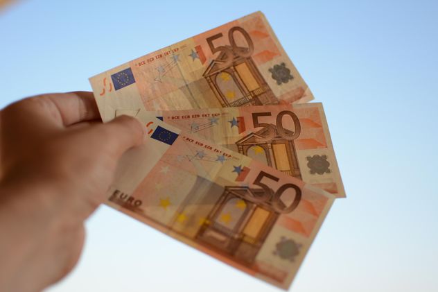 Euro banknotes in hand on blue background - бесплатный image #348421