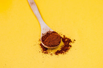 Red pepper spice on wooden spoon. Yellow background - image #448911 gratis