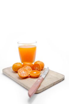 Oranges on the desk with knife and glass of juice on white background - бесплатный image #452521