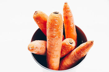 Top view of carrots in a bowl. White background . Close up - Free image #454241