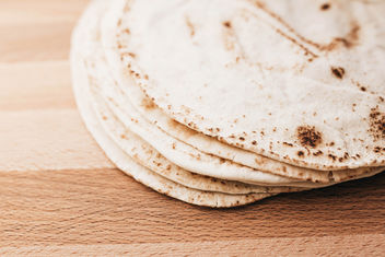 Stack of pita bread on wooden board - Free image #456981