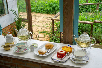 Glass Tea Pots, Tea Cups, Plates and other Ceramics on a Wooden Windowsill facing a Garden - image gratuit #475811 