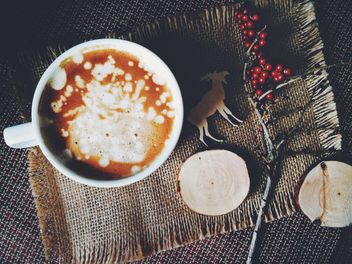 Cup of coffee and branch with red berries on sacking - бесплатный image #136261