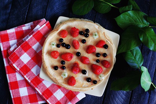 Pancakes with berries, checkered dishcloth and plant - image gratuit #136461 