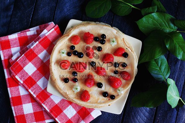 Pancakes with berries, checkered dishcloth and plant - image #136461 gratis