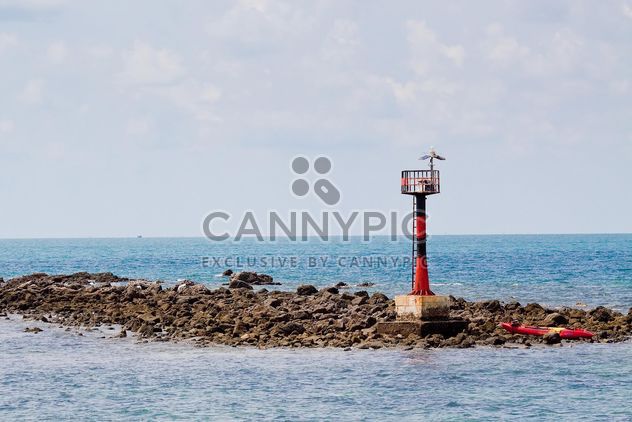 Lighthouse on rocks - image #183441 gratis