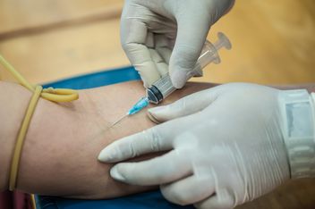 Doctor drawing blood from patient with syringe - бесплатный image #186341