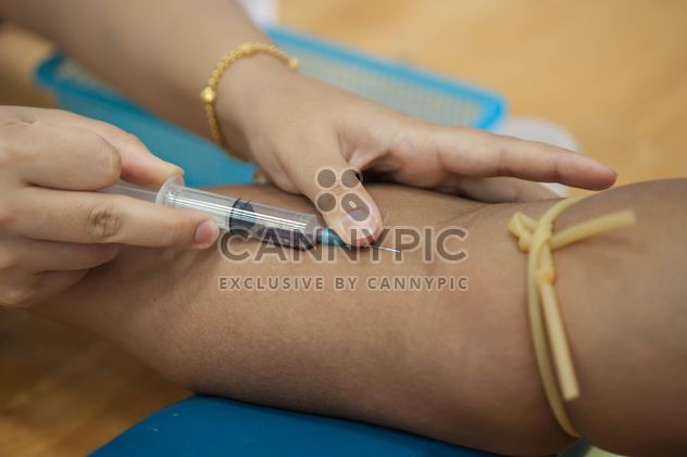 Doctor drawing blood from patient with syringe - бесплатный image #186581