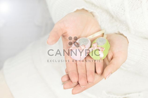 Baby's bootees in hands of woman - бесплатный image #186721