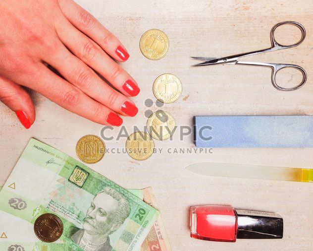 Female hand, money and accessories for manicure on wooden background - бесплатный image #198961