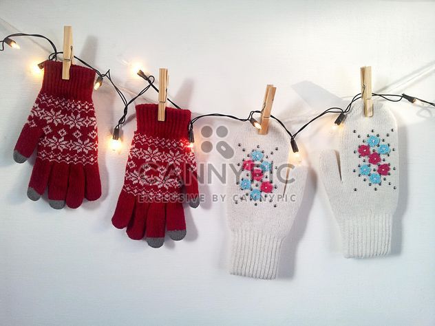 Woolen mittens hanging on rope with clothespins - бесплатный image #272301