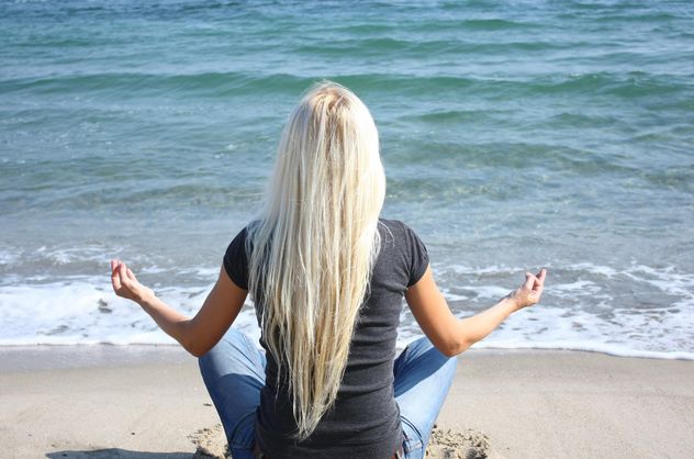 Blond girl meditating on a beach - image #273941 gratis
