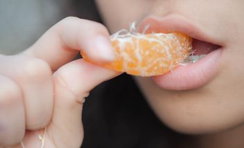 Girl eating peeled tangerine - image #301941 gratis