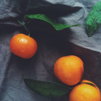 tangerines and green leaves on a blue background - бесплатный image #329211