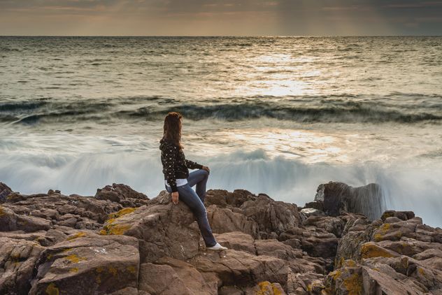 Woman sitting on rock in sea - Free image #338601
