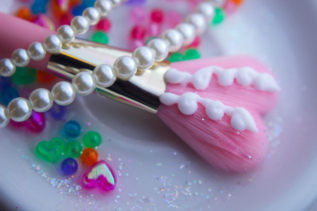 Pink makeup brush and pearls on a plate - бесплатный image #341501