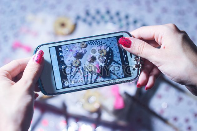 Smartphone decorated with tinsel in woman hands - бесплатный image #342181