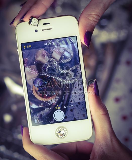 Smartphone decorated with tinsel in woman hands - image gratuit #342191 