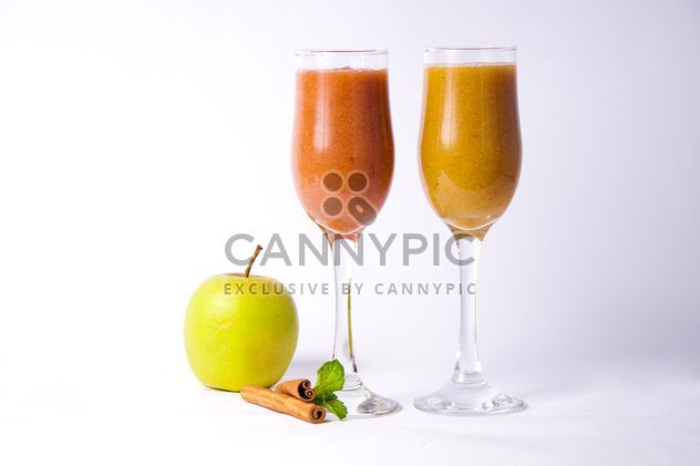 Citrus fresh juice in two glasses with cinnamon and apple - image #342501 gratis
