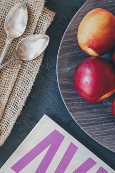 Still life of apples on a plate, two spoons and magazine - Free image #342591