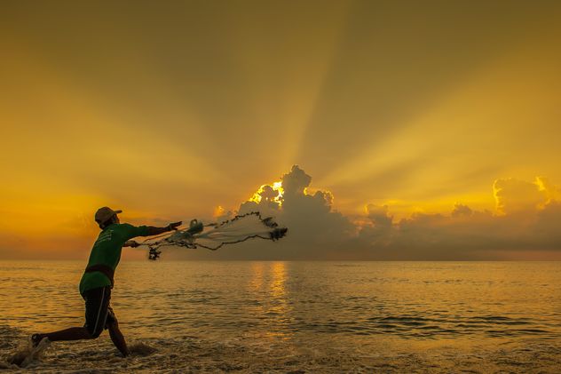 Fisherman throwing a net at sunset - Free image #344091