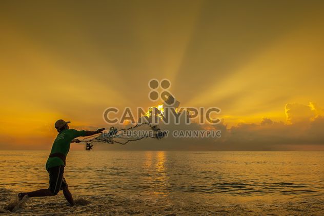 Fisherman throwing a net at sunset - Free image #344091