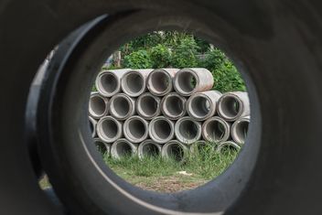 Concrete drainage pipes stacked on grass - бесплатный image #344581