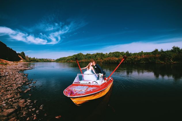 Happy wedding couple in boat on lake - image #345111 gratis