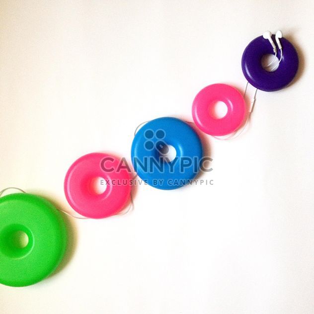 Earphones and colorful rings on white background - Free image #346561