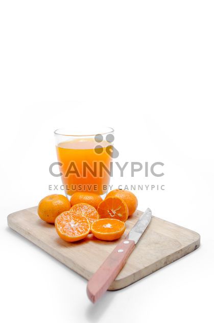 Oranges on the desk with knife and glass of juice on white background - Free image #452521