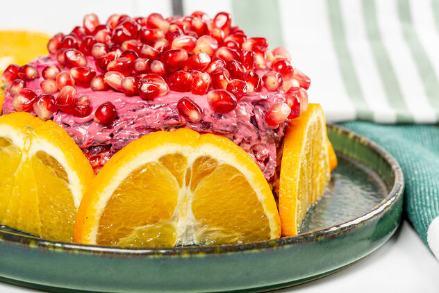 Layered salad composed of pickled herring covered with layers of boiled grated vegetables, orange and pomegranate - Free image #477321